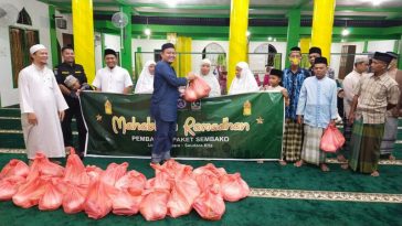 Prosesi pembagian paket sembako kepada masyarakat oleh MW KAHMI Kepri, Prodi Ilmu Hukum FISIP Umrah, dan Dewan Dakwah Kepri saat menggelar Mahabbah Ramadhan 1443 H/2022 di salah satu masjid, April 2022. Foto Lihatkepri.com